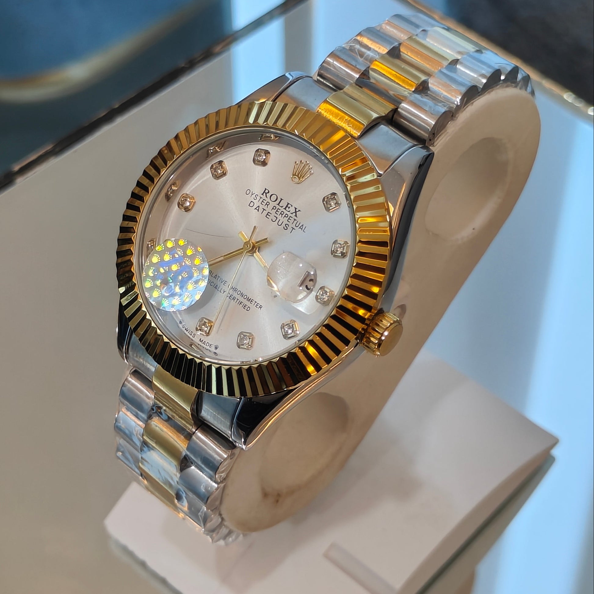 Gold and silver watch on a display stand with a blurred background